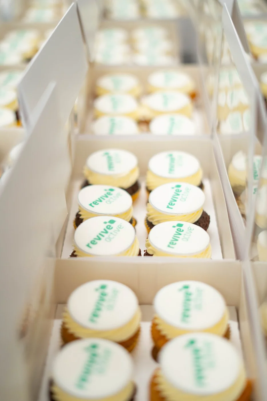 Boxes of cupcakes with the Revive Active logo