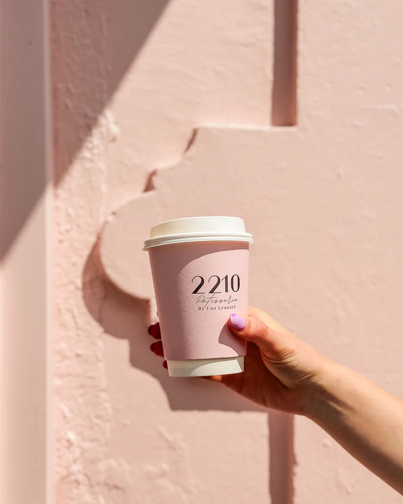 A 2210 coffee against the pink wall